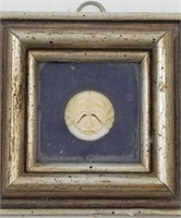 Small ivory button mounted onto a small wall hangi