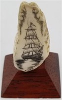 Scrimshawed fossilized walrus tooth of a sailing v