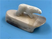 Small ivory carving of a polar bear on fossilized