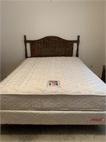 Queen size bed with carved detail on headboard.