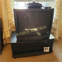 Large TV with TV table that has glass tinted