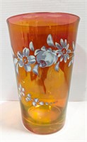 Large red glass vase with painted floral pattern.