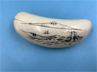 Scrimshawed whale's tooth, depicting a window on a