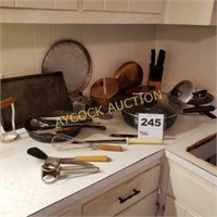 Counter full of pots & pans, knives, 2 cast iron