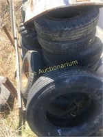 Pile of tires rims misc items behind container