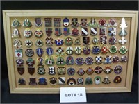 Eighty two vintage military pins mounted on cork b