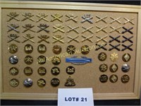 Sixty military pins mounted on corkboard