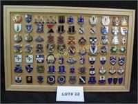 Seventy eight vintage military pins mounted on cor