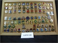 Eighty five vintage military pins mounted on cork