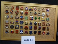 Sixty military pins mounted on corkboard