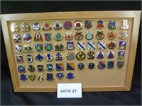 Sixty one vintage military pins mounted on cork bo