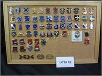 Sixty vintage military pins mounted on cork board
