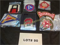 Six military patches and a shoulder tab