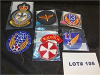 Six military patches and a shoulder tab