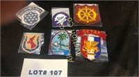 Six military patches and a tab