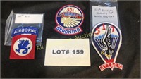 Three military patches and a tab