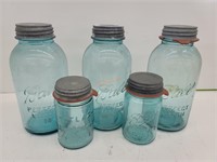 3 blue half gallon ball jars and 2 quart jars