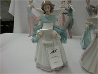 Lladro figure of an angel reading.
