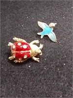 A ladybug and a blue bird pendant