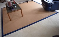 Rattan style woven area rug with blue border
