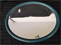 Large heavy oval mirror with wooden frame.
