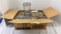 Twelve pint style canning jars with lids. Four