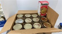 One box of twelve canning jars with lids and an