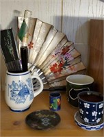 Asian fans, ceramic mugs, decorative plate