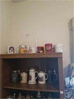 Group of mugs and steins. Contents of 2 shelves