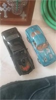 2 diecast cars a black firebird and a blue