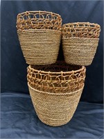 Set of three wicker baskets with metal frames.