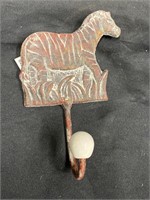 Zebra coat hook with a porcelain knob. 7 inches