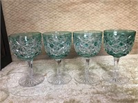 Four green cut glass glasses