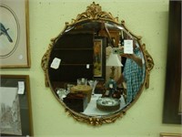 Round Art Deco gilt beveled wall mirror.