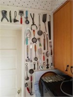 Wall of vintage kitchen utensils.