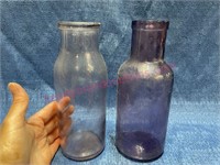 (2) purple glass bottles -8in tall