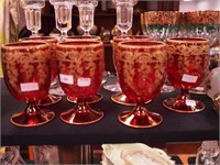 Seven 5" high water goblets of red art glass