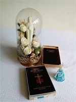 Virgin Mary figurine under glass and 2 books.