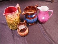 Four vintage pottery pitchers: two are