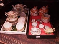 Two containers of children's china tea sets; one