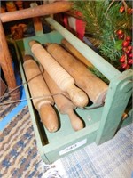 Wood rolling pins in wood carrier, dog on bed
