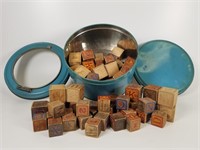 Wooden letter blocks in a biscuit tin