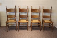Four oak hip rest chairs with rush seats