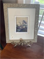 Signed matted and glass framed print on stand