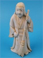Ivory carving of a Japanese man holding a broom, a