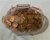 Clear glass coin piggy bank full of pennies. 6