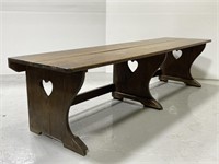 Long vintage wooden bench pew with heart cutout