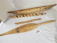 small wooden carved canoe with paddle