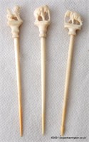 A group of Three Carved Bone Cocktail Stick