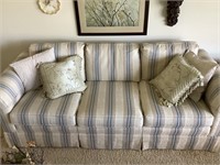 Stripped floral couch with decorative pillows,